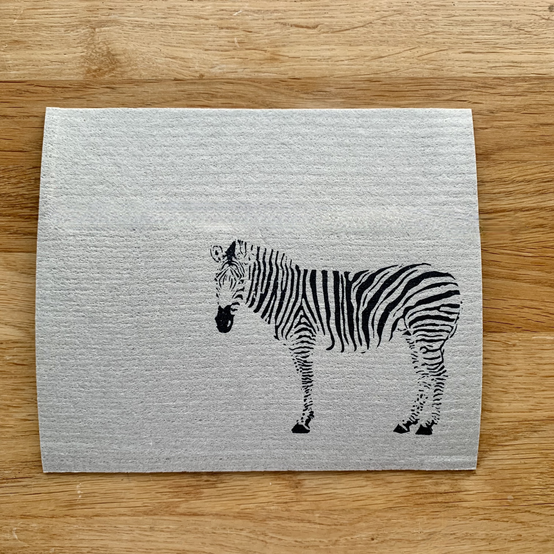 Graues Schwammtuch mit schwarzem Zebra Handbedrucktes graues Schwammtuch mit schwarzem Zebra