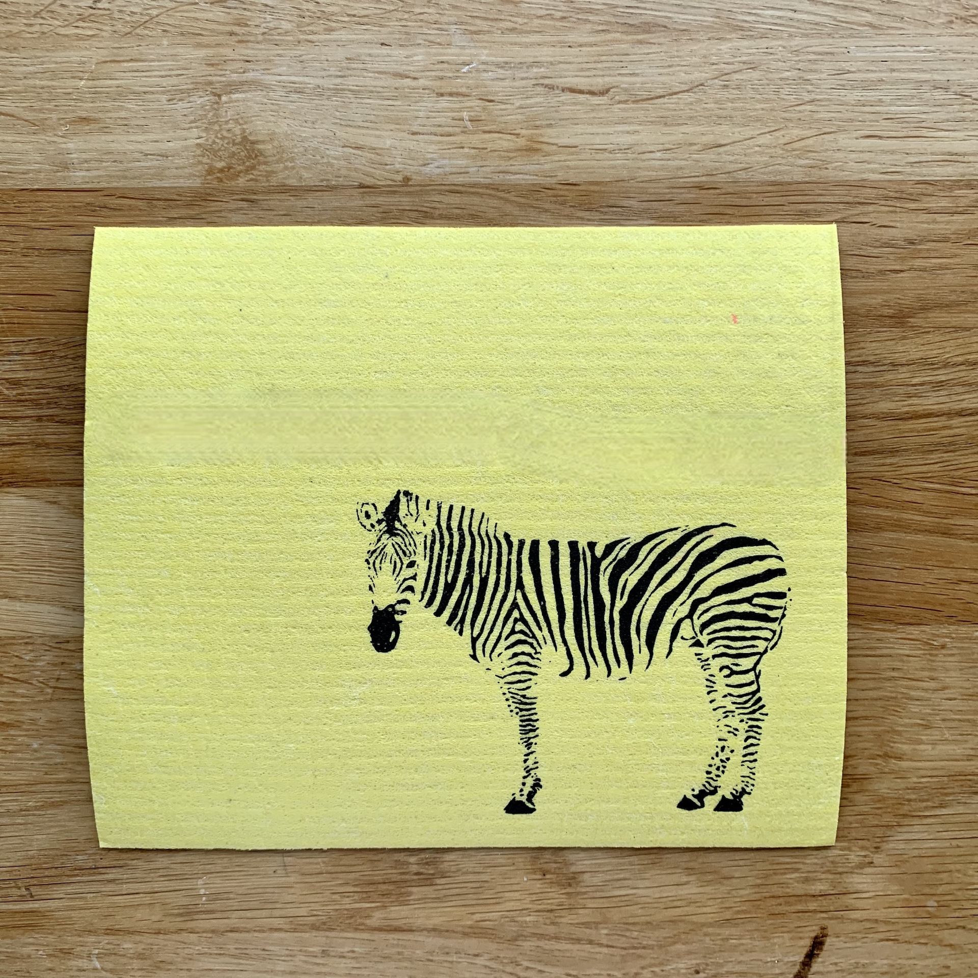 Gelbes Schwammtuch mit schwarzem Zebra Handbedrucktes gelbes Schwammtuch mit schwarzem Zebra