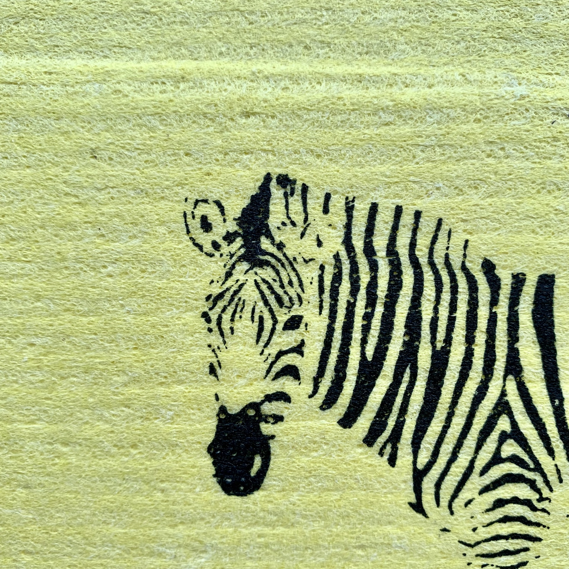 Gelbes Schwammtuch mit schwarzem Zebra Handbedrucktes gelbes Schwammtuch mit schwarzem Zebra